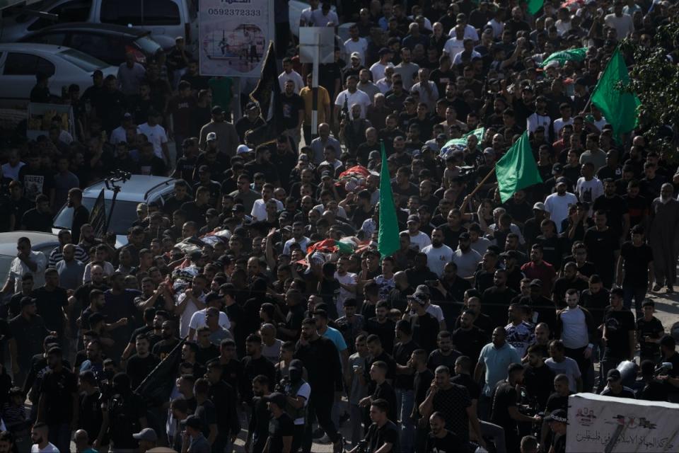 Flags and banners of Hamas and Islamic Jihad fly at the funeral of those slain at Nur Sham (AP)