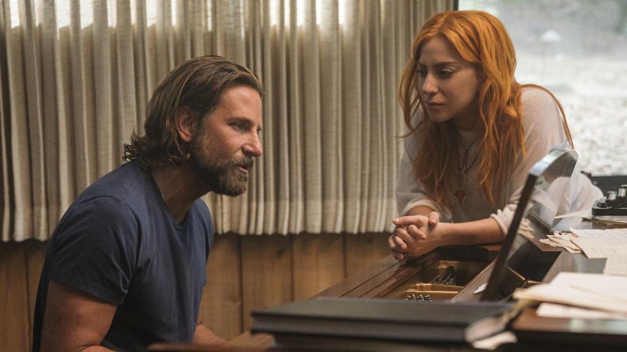  Lady Gaga watching as Bradley Cooper sings while playing piano in A Star is Born. 