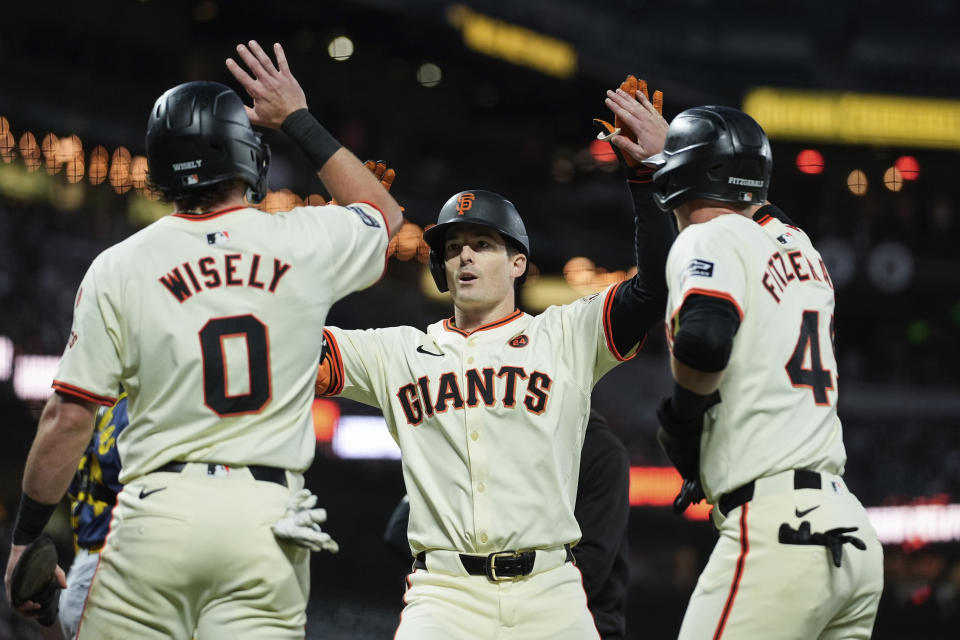 San Francisco Giants' Mike Yastrzemski, center, celebrates with Brett Wisely, left, and Tyler Fitzgerald after hitting a three-run home run during the second inning of a baseball game against the Milwaukee Brewers, Wednesday, Sept. 11, 2024, in San Francisco. (AP Photo/Godofredo A. Vasquez)