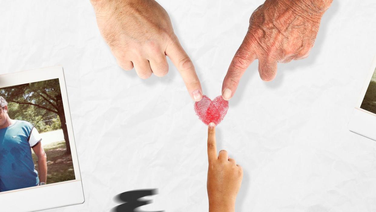 a hand holding a strawberry