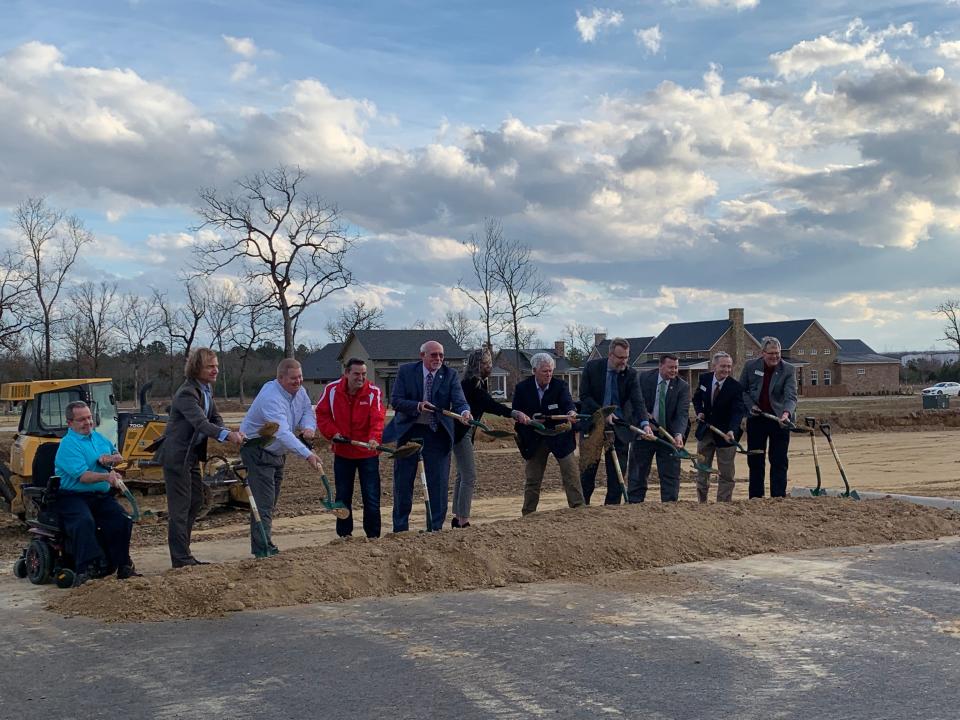 ACHE officials braved Wednesday afternoons wind to kick off the ground breaking of the college's new $22.5 million Building C at The Village at Heritage