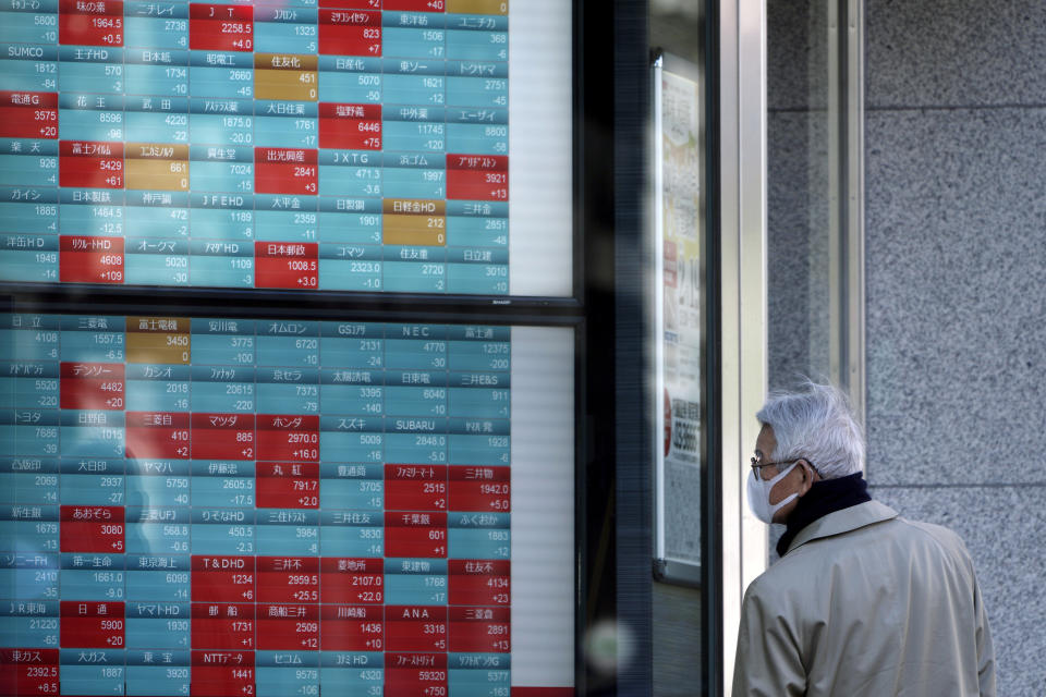 A man looks at an electronic stock board showing Japan's Nikkei 225 index at a securities firm in Tokyo Tuesday, Feb. 18, 2020. Shares have fallen in Asia as the impact from the virus outbreak that began in China deepened, with Apple saying it would fail to meet its profit target and China moving to cancel major events including the Beijing auto show. (AP Photo/Eugene Hoshiko)