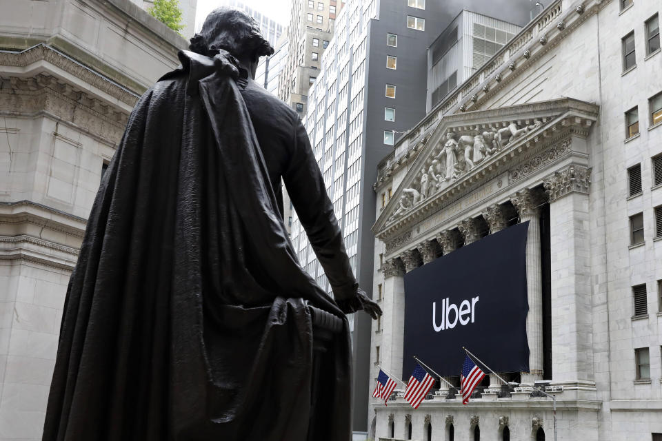 La estatua de George Washington frente a un letrero de Uber que cuelga en la fachada de la bolsa de valores de Nueva York, el viernes 10 de mayo de 2019. (AP Foto/Richard Drew)