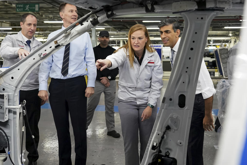 Britain's Prime Minister Rishi Sunak, right and Chancellor of the Exchequer Jeremy Hunt are shown around, during a visit to the car manufacturer Nissan, in Sunderland, England, Friday, Nov. 24, 2023. Nissan will invest more than $1.3 billion to update its factory in northeast England to make electric versions of its two best-selling cars. It's a boost for the British government as it tries to revive the country’s ailing economy. The Japanese automaker manufactures the gasoline-powered Qashqai and smaller Juke crossover vehicles at the factory in Sunderland, which employs 6,000 workers. (Ian Forsyth/Pool Photo via AP)