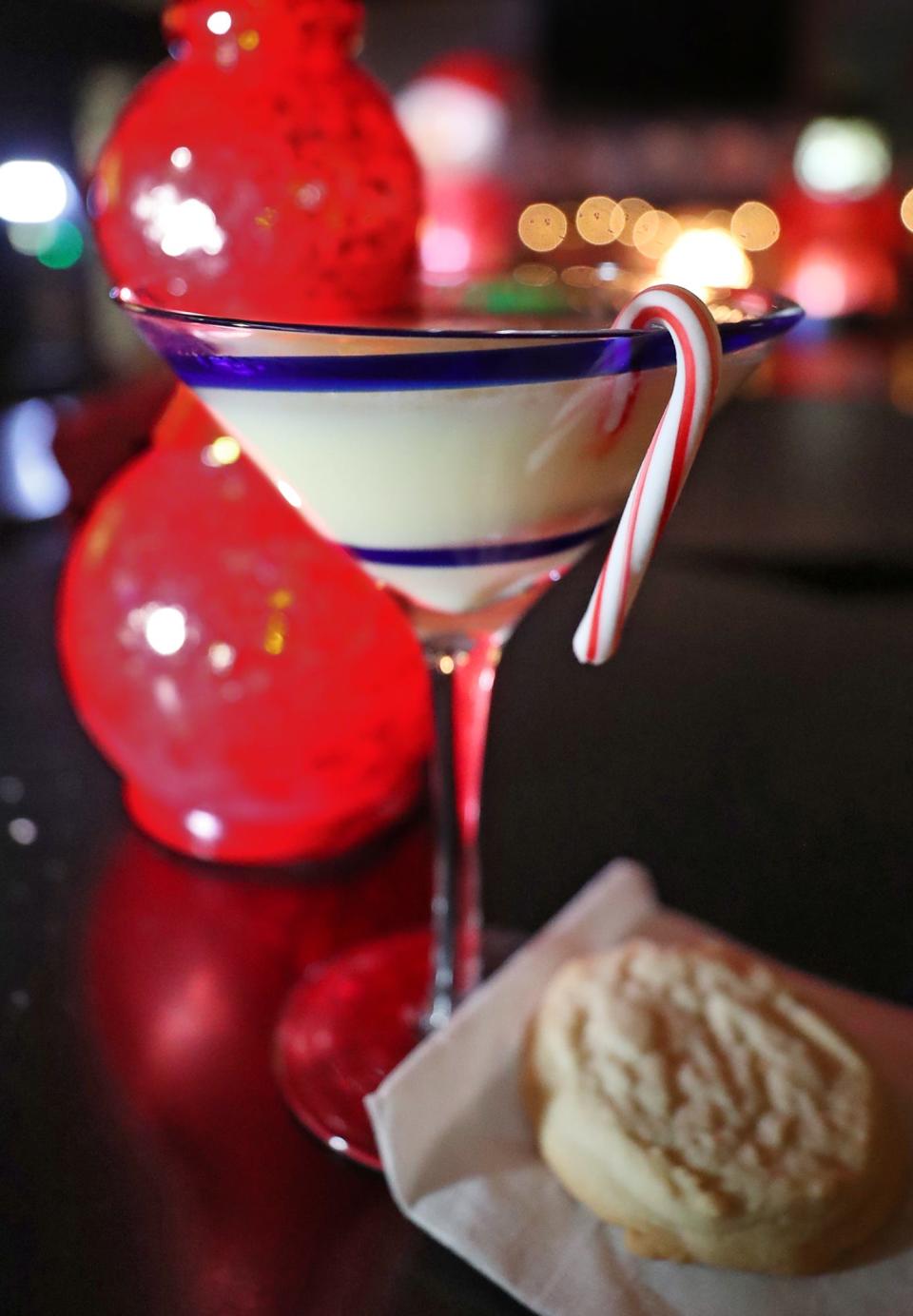 Holiday drink "You Filthy Animal! " which has eggnog, a double shot of rum and is served with a Christmas cookie at President's Lounge. The Akron bar has transformed to the Reindeer Room for the holiday season.
(Photo: Mike Cardew, Akron Beacon Journal)