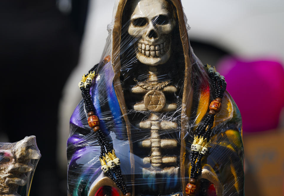 Los vendedores exhiben estatuas ornamentadas de "La Santa Muerte", en el barrio de Tepito de la Ciudad de México, el martes 1 de noviembre de 2022. La Santa Muerte es una imagen de culto y un santo popular, una personificación de la muerte, asociada con la curación, la protección y la entrega segura al más allá por parte de sus devotos. (AP Foto/Fernando Llano)