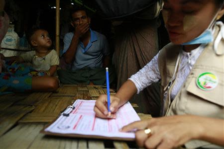 A volunteer collects data from an ethnic Kaman family living in a Rohingya refugee camp during a national census in Sittwe, the capital of Rakhine State April 1, 2014. REUTERS/Soe Zeya Tun