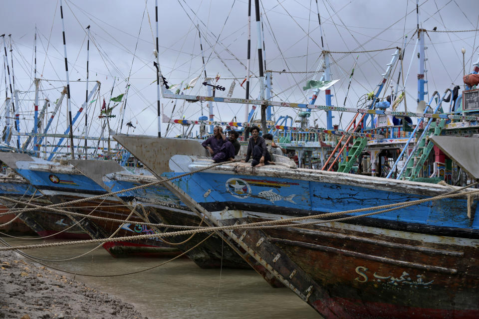Fishermen sit on their boats, which are anchored following authorities alerting of Cyclone Biparjoy approaching, at a costal area of Keti Bandar near Thatta, Pakistan's southern district in the Sindh province, Wednesday, June 14, 2023. The coastal regions of India and Pakistan were on high alert Wednesday with tens of thousands being evacuated a day before Cyclone Biparjoy was expected to make landfall. (AP Photo/Fareed Khan)