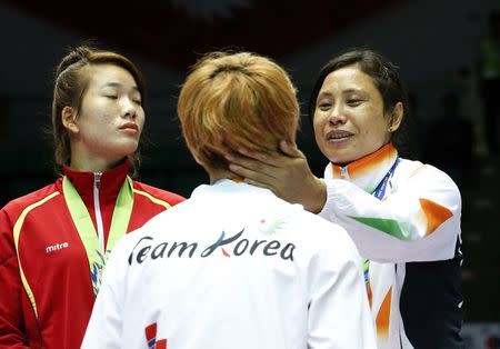 India's bronze medallist Laishram Sarita Devi (R) talks with South Korea's silver medallist Park Ji-na during the medal ceremony for the women's light (57-60kg) boxing competition at the Seonhak Gymnasium during the 2014 Asian Games in Incheon October 1, 2014. REUTERS/Kim Kyung-Hoon