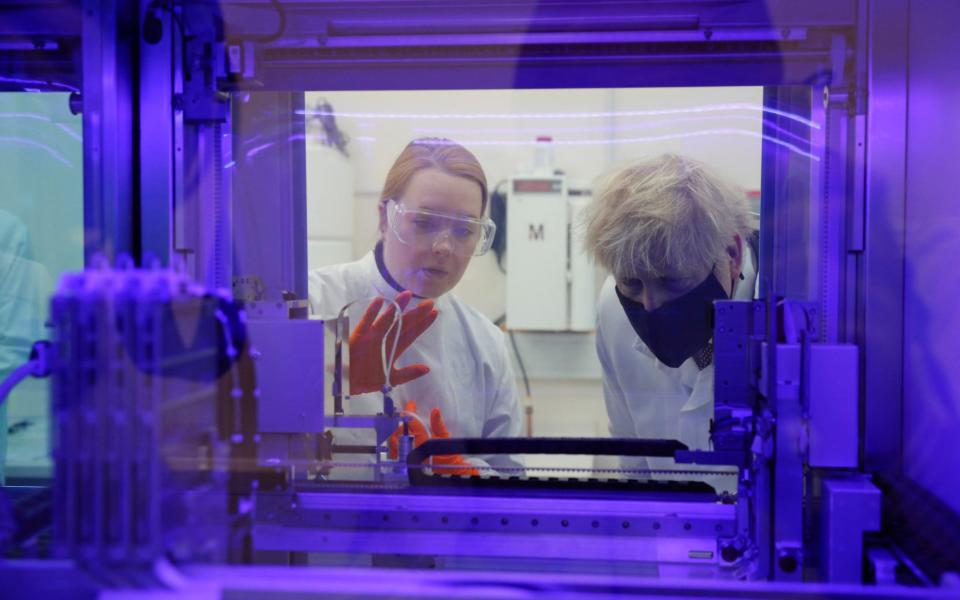 Prime Minister Boris Johnson views a PCR diagnostics machine with biomedical scientist Jodie Owen, left, in a laboratory during a visit to the Public Health England site at Porton Down science park near Salisbury. Friday Nov 27, 2020. -  Adrian Dennis/POOL AFP