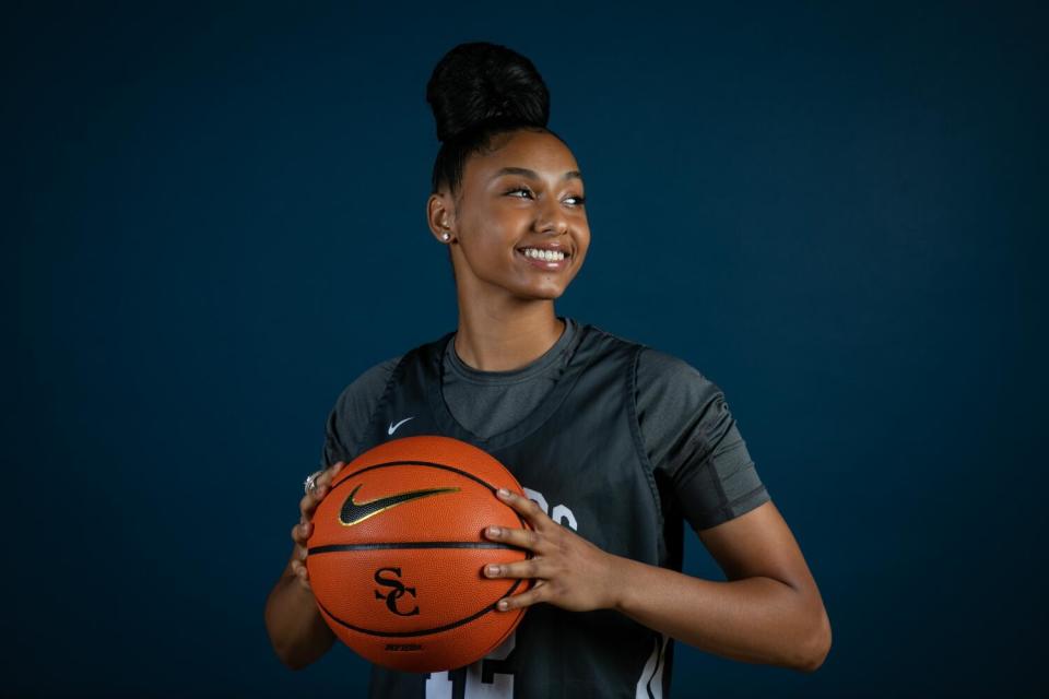JuJu Watkins of Sierra Canyon poses for a photo while holding a basketball with two hands.