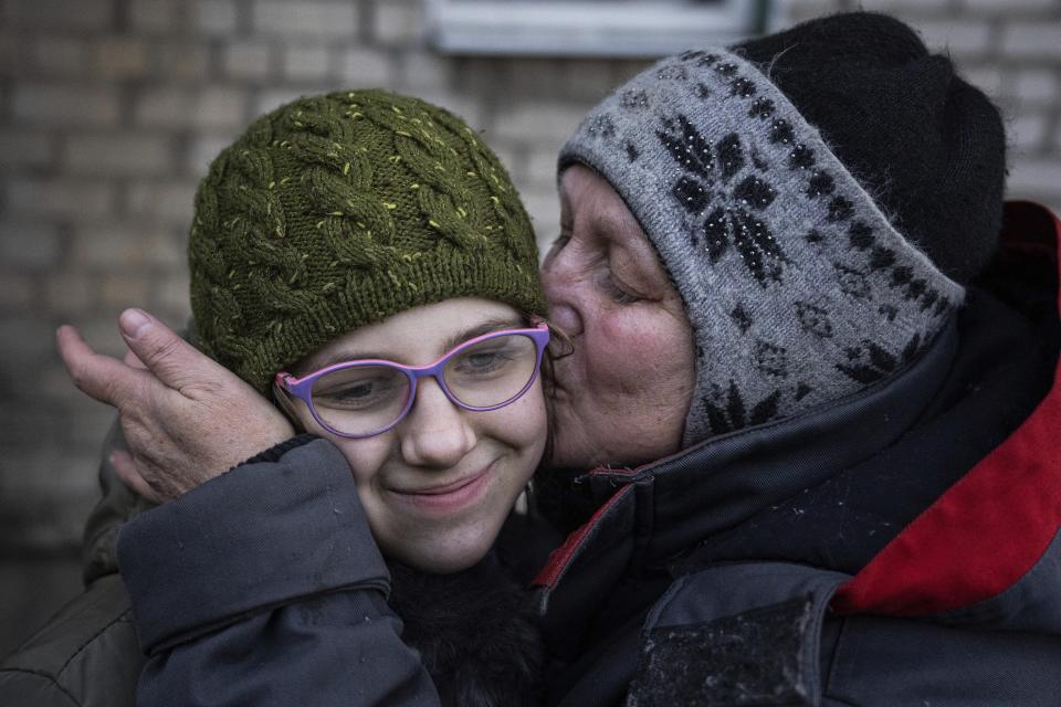 Arina, left, receives a kiss by her neighbour during an evacuation by Ukrainian police in Avdiivka, Ukraine, Tuesday, March 7, 2023. For months, authorities have been urging civilians in areas near the fighting in eastern Ukraine to evacuate to safer parts of the country. But while many have heeded the call, others -– including families with children -– have steadfastly refused. (AP Photo/Evgeniy Maloletka)