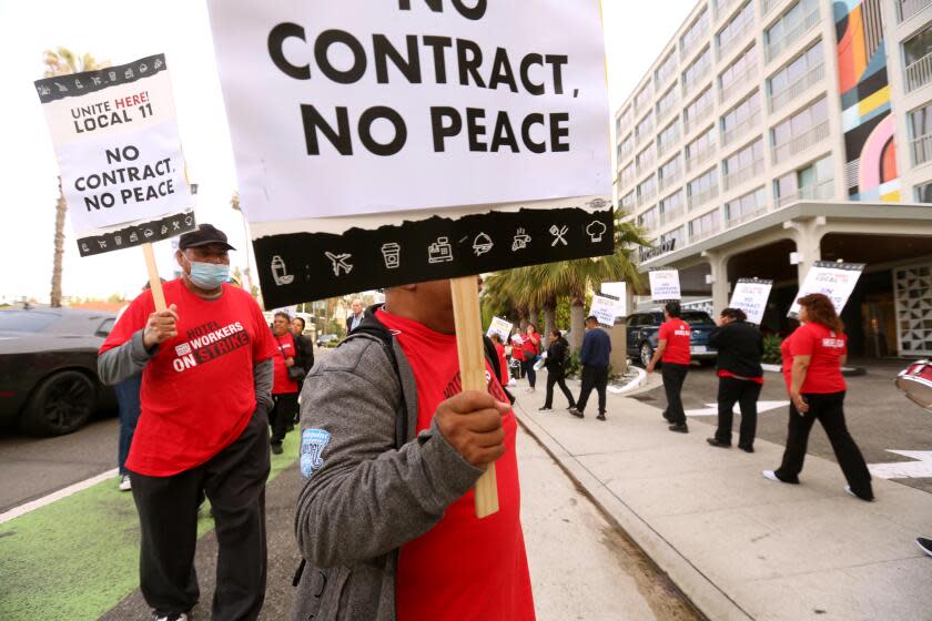 SANTA MONICA, CA - JULY 12, 2023 - Jose Ayala, 66, left, walks the picket line with fellow Unite Here Local 11 hotel workers in front of the Viceroy Hotel in Santa Monica on July 12, 2023. Ayala works as a dishwasher for the Viceroy Hotel and has to work a second job to make ends meet. Some older hotel workers scrape by on their income and can't afford to quit. Some work two jobs just to make ends meet. Unite Here Local 11 hotel employees have been striking for higher pay and better benefits. (Genaro Molina/Los Angeles Times)