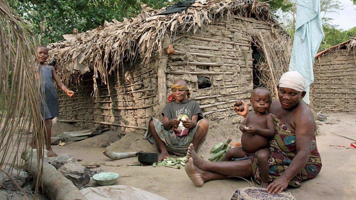 Eine Pygmäen-Frau vom Volk der Basua bereitet im Westen von Uganda vor einer Hütte Essen zu. Foto: Helena Landstedt/EPA/Archiv