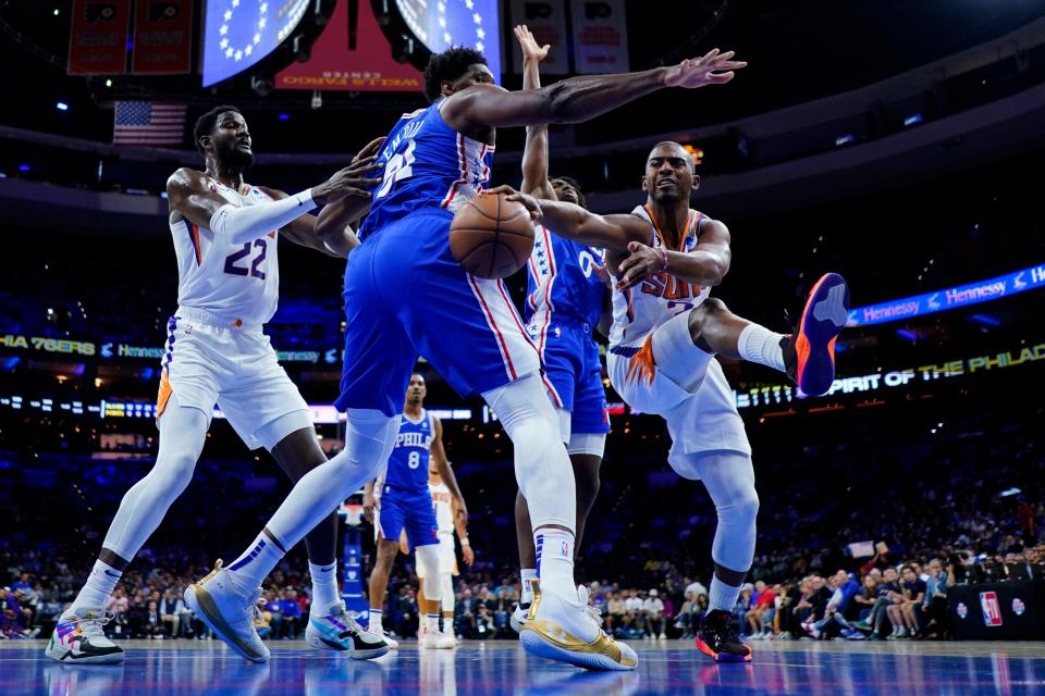 Phoenix Suns' Chris Paul, right, tries to pass around Philadelphia 76ers' Joel Embiid during the first half of an NBA basketball game, Monday, Nov. 7, 2022, in Philadelphia. (AP Photo/Matt Slocum)