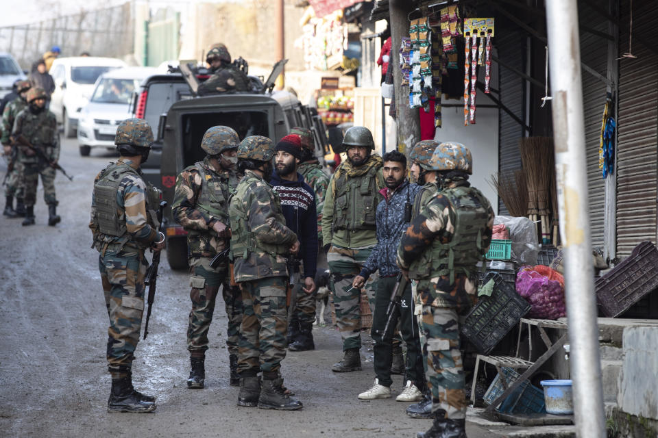 Indian security officers interrogate civilians near the site of an attack on the outskirts of Srinagar, Indian controlled Kashmir, Thursday, Nov. 26, 2020. Anti-India rebels in Indian-controlled Kashmir Thursday killed two soldiers in an attack in the disputed region’s main city, the Indian army said.(AP Photo/Mukhtar Khan)