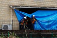 Firefighters check the torced Kyoto Animation building in Kyoto