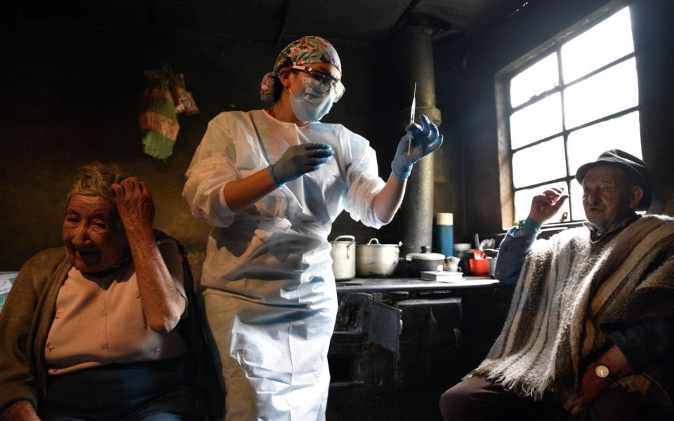 A nursing assistant prepares to give a vaccine during a door-to-door vaccination campaign to immunise people in rural areas of Bogota - Guillermo Legaria/Getty Images