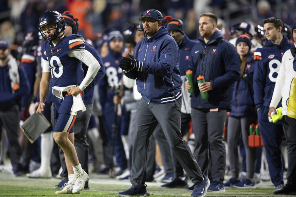 Virginia coach Tony Elliott walks on the field during a timeout in the second half of the team's NCAA college football game against Virginia Tech on Saturday, Nov. 25, 2023, in Charlottesville, Va. (AP Photo/Mike Caudill)