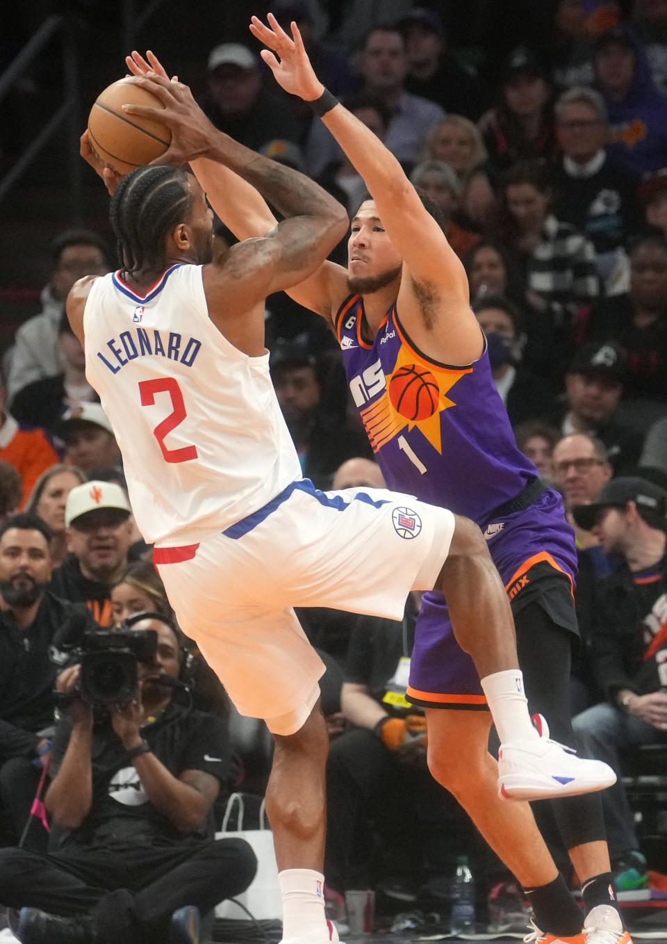 Feb 16, 2023; Phoenix, Arizona, USA; Phoenix Suns guard Devin Booker (1) defends Los Angeles Clippers forward 	Kawhi Leonard (2) at Footprint Center. 