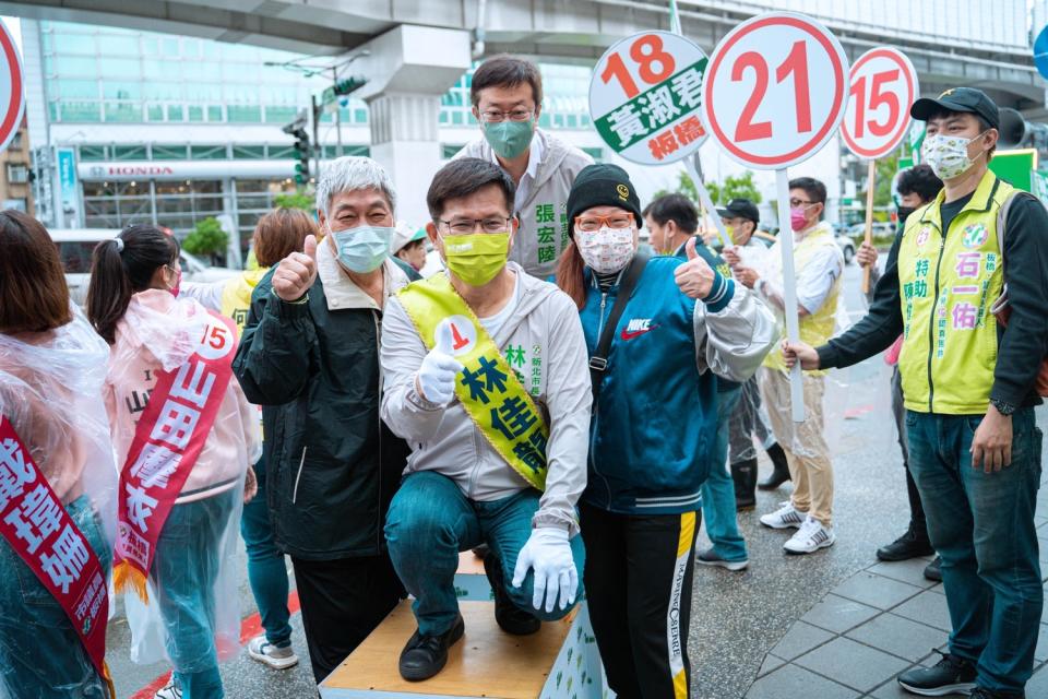 林佳龍偕市議員候選人冒雨在板橋區站路口拜票，民眾熱情回應。   圖：林佳龍競辦提供