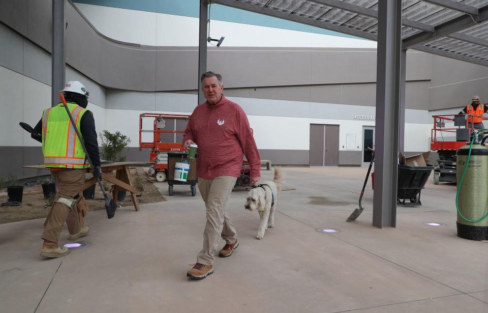 Tim Leiweke walks with his dog as construction continues at the Acrisure Arena in Palm Desert, Calif., Dec. 12, 2022.