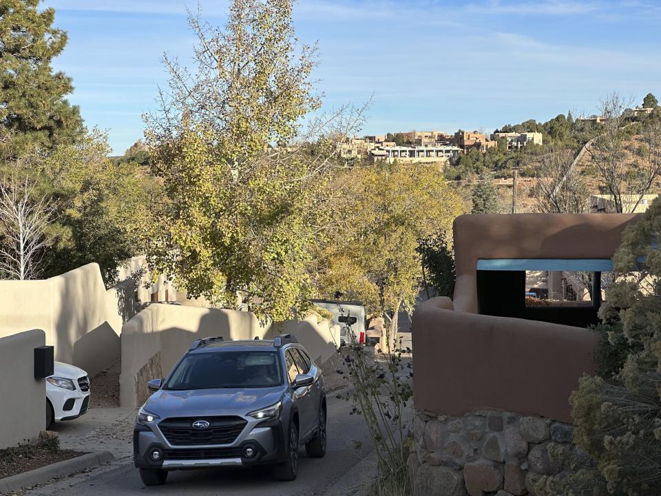 A car navigates narrow streets among million-dollar homes in Santa Fe, N.M., on Friday, Nov. 3, 2023. Voters are deciding whether to tax mansions to pay for affordable housing initiatives in a state capital city prized for its desert-mountain vistas, vibrant arts scene and stucco architecture rooted in Native American and Spanish-colonial tradition. (AP Photo/Morgan Lee)