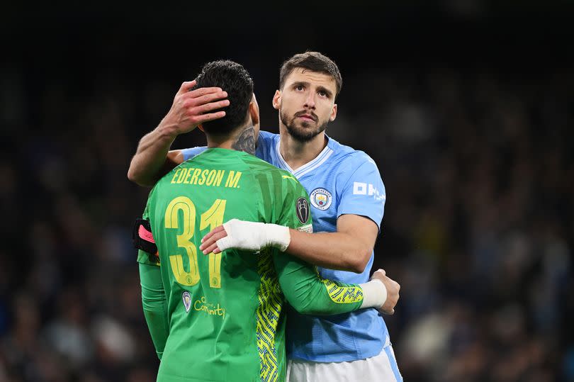 Ruben Dias consoles Ederson of Manchester City after the team's defeat in the penalty shoot out during the UEFA Champions League quarter-final second leg match between Manchester City and Real Madrid CF at Etihad Stadium on April 17, 2024 in Manchester, England.