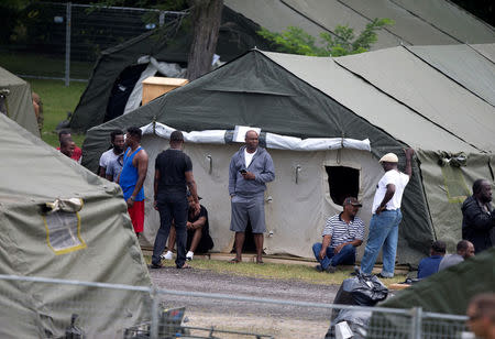 A group of asylum seekers stand in their tent encampment in Lacolle, Quebec Canada August 11, 2017. REUTERS/Christinne Muschi