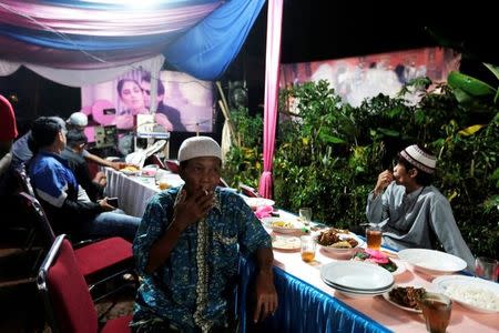 Villagers watch films during a wedding party in Bogor, Indonesia, May 2, 2017. REUTERS/Beawiharta/Files