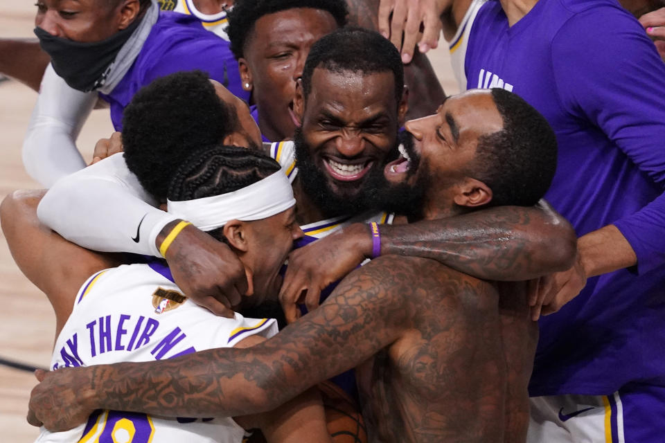 FILE - In this Oct. 11, 2020, file photo, Los Angeles Lakers' LeBron James (23) celebrates with his teammates after the Lakers defeated the Miami Heat 106-93 in Game 6 of basketball's NBA Finals in Lake Buena Vista, Fla. The photo was honored by the Associated Press Sports Editors as best sports feature photo of 2020 at their annual winter meeting. (AP Photo/Mark J. Terrill, File)