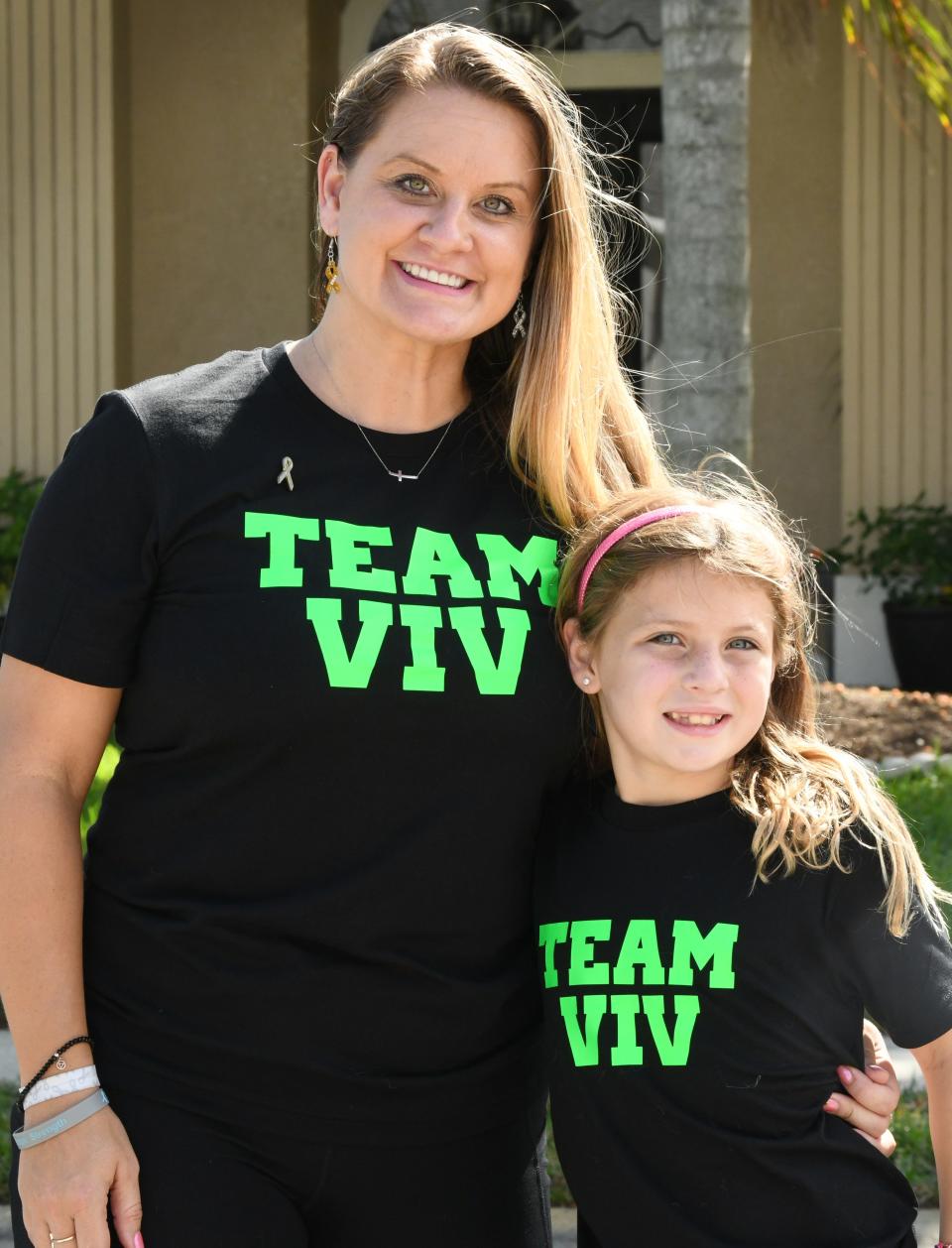 Brittany Sleeth and her 7-year-old daughter Viv pose for a photo before shaving their heads Sunday afternoon in their Rockledge driveway.