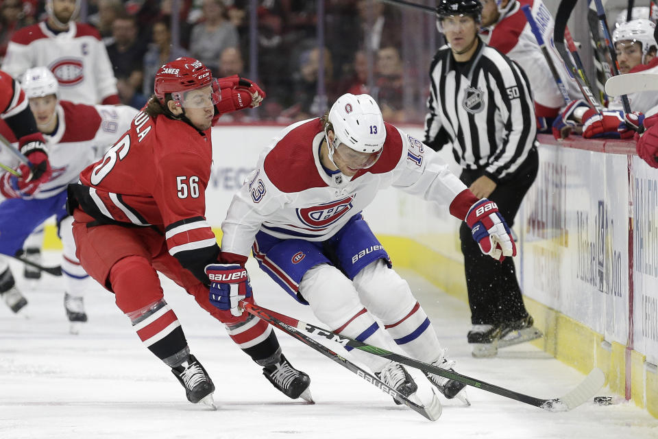Carolina Hurricanes left wing Erik Haula (56), of Finland, reaches across Montreal Canadiens center Max Domi (13) during the first period of an NHL hockey game in Raleigh, N.C., Thursday, Oct. 3, 2019. (AP Photo/Gerry Broome)
