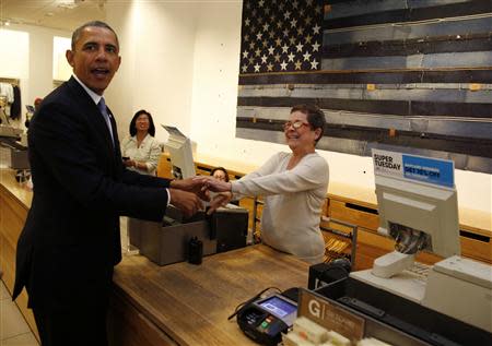 U.S. President Barack Obama shakes hands with cashier Sonia Del Gatto while he looks for gifts for his family after stopping off at the GAP in New York, March 11, 2014. REUTERS/Larry Downing (