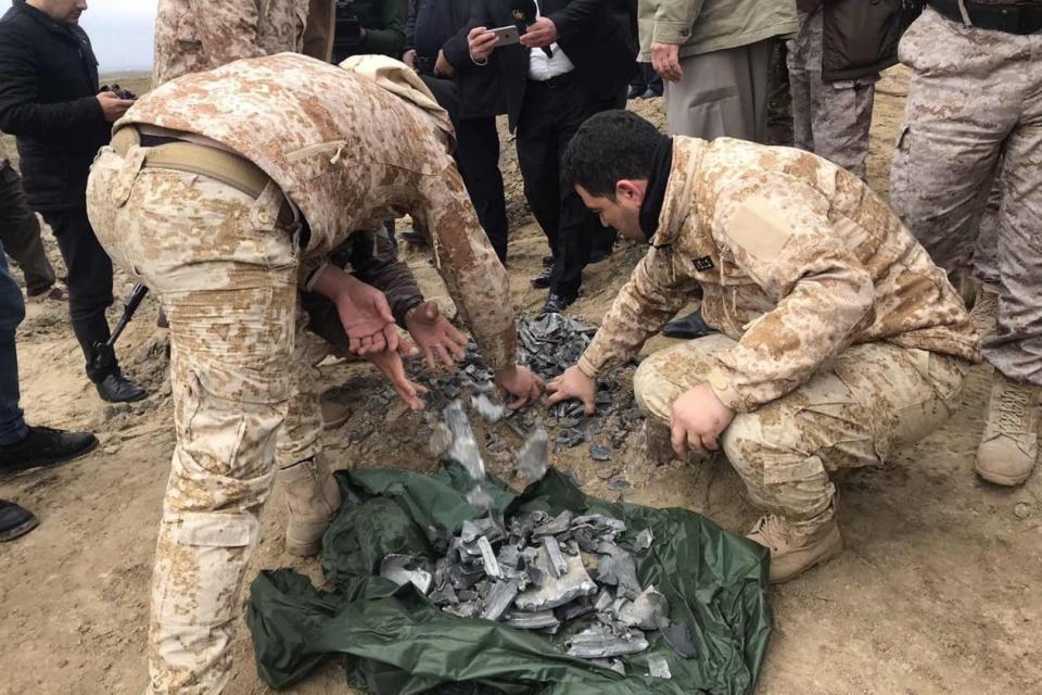 Iraqi security forces find and collect the pieces of missiles (Anadolu Agency via Getty Images)