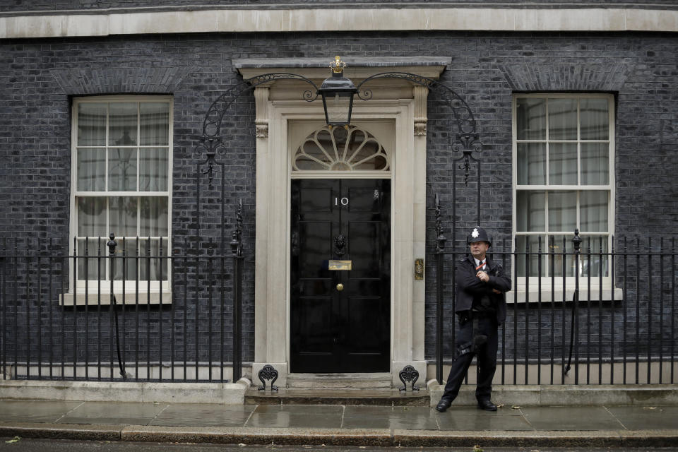 FILE - In this file photo dated Friday, June 7, 2019, a police officer stands guard outside the front door to the official residence of Britain's Prime Minister, 10 Downing Street, London. Lawmakers are set to narrow the field of contenders for leadership of the Conservative Party and Prime Minister, in a series of elimination votes over the coming days from Monday June 17, 2019, with the final two names put to a vote of Conservative party members nationwide. The six contenders to replace Prime Minister Theresa May are: Michael Gove, Jeremy Hunt, Sajid Javid, Boris Johnson, Dominic Raab, Rory Stewart. (AP Photo/Matt Dunham, FILE)