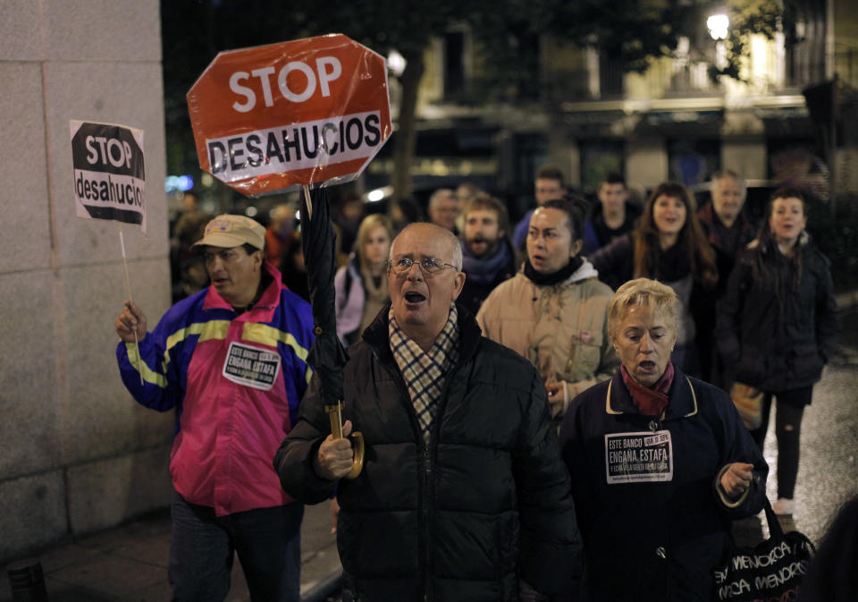 People hold banners that read: "Stop Evictions", during a march against evictions, in Madrid, Friday, Nov. 9, 2012. Officials say a woman fell to her death as bailiffs approached to evict her for non-payment of the mortgage from her fourth-floor apartment in a suburb of the northern Spanish city of Bilbao. Amaia Egana, 53-year-old, who worked at a local bus depot, was married to a former town councilor and had a 21-year-old daughter, launched herself off her balcony Friday, the regional Interior Ministry said. (AP Photo/Andres Kudacki)