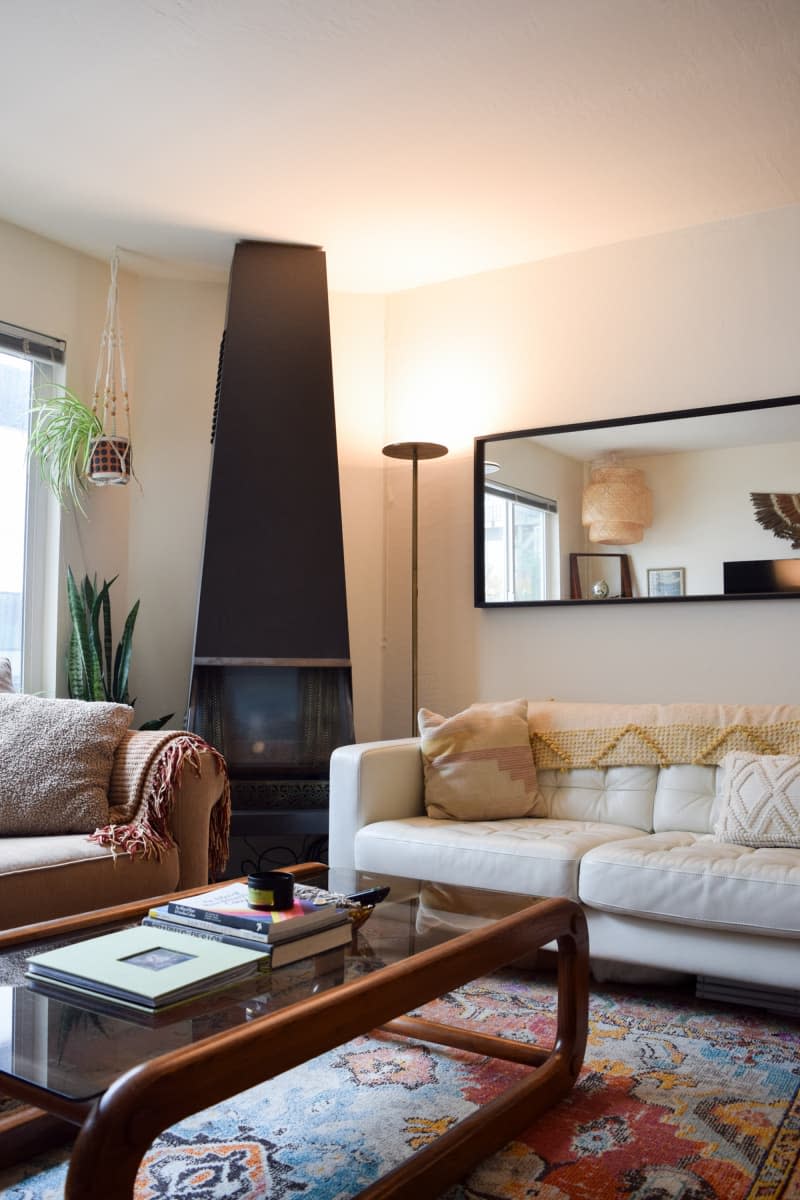 Black fireplace in the corner of the living room flanked by two couches