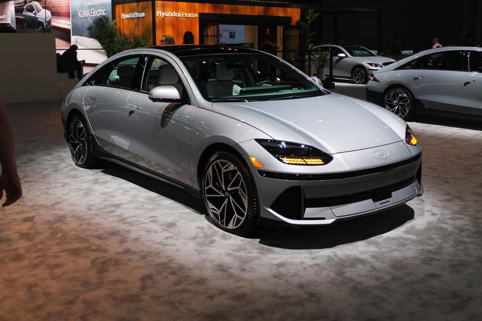 A silver Hyundai Ioniq 6 Sedan illuminated on a carpeted floor at the New York auto show.