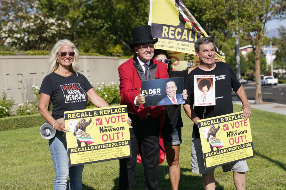 Supporters of the California recall of Gov. Gavin Newsom and Republican candidate Larry Elder hold signs outside of a debate by Republican gubernatorial candidates at the Richard Nixon Presidential Library Wednesday, Aug. 4, 2021, in Yorba Linda, Calif. Newsom faces a Sept. 14 recall election that could remove him from office. (AP Photo/Marcio Jose Sanchez)