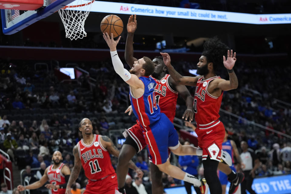 Detroit Pistons guard Malachi Flynn (14) drives on Chicago Bulls center Adama Sanogo (21) and Coby White (0) in the second half of an NBA basketball game in Detroit, Thursday, April 11, 2024. (AP Photo/Paul Sancya)