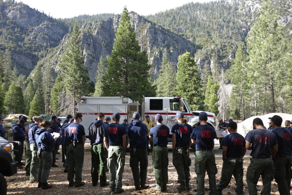 In this June 10, 2019 photo, burn boss Andrew Cremers briefs firefighters from Sequoia and Kings Canyon National Parks before the start of a two-day prescribed burn in Cedar Grove in Kings Canyon National Park, Calif. The prescribed burn, a low-intensity, closely managed fire, was intended to clear out undergrowth and protect the heart of Kings Canyon National Park from a future threatening wildfire. The tactic is considered one of the best ways to prevent the kind of catastrophic destruction that has become common, but its use falls woefully short of goals in the West. (AP Photo/Brian Melley)