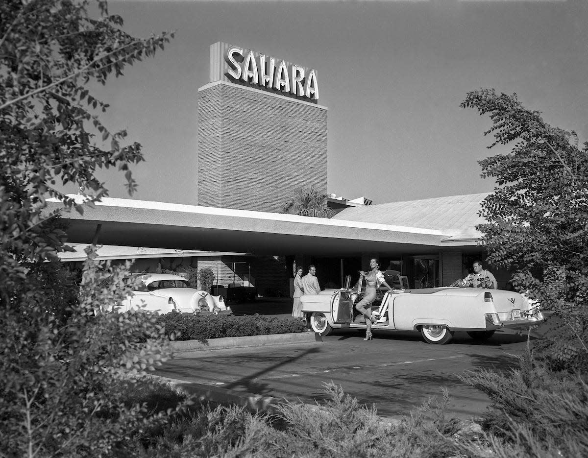 This is an exterior view of the Sahara and its porte cochere, showing models entering the hotel and exiting a car, in Las Vegas, Nevada on August 18, 1954. (Las Vegas News Bureau Collection, LVCVA Archive)