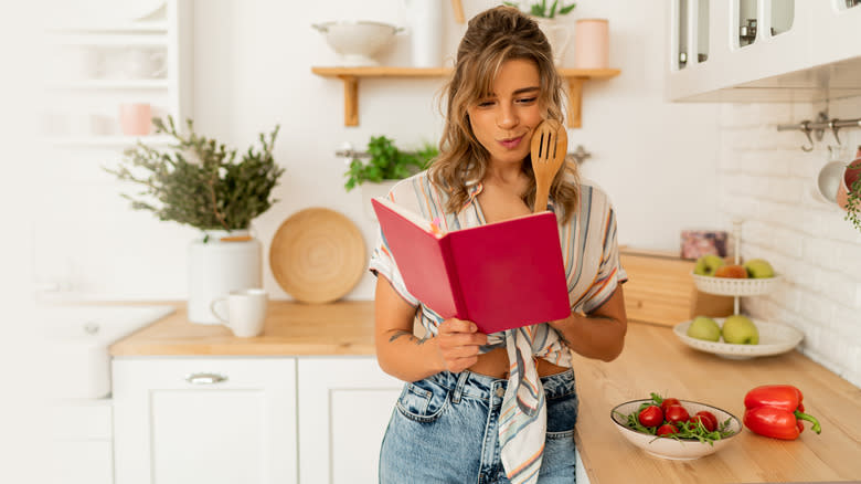 woman smiling reading cookbook
