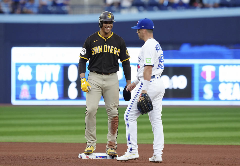 San Diego Padres' Juan Soto, left, smiles next to Toronto Blue Jays second baseman Whit Merrifield during the fourth inning of a baseball game Wednesday, July 19, 2023, in Toronto. (Chris Young/The Canadian Press via AP)