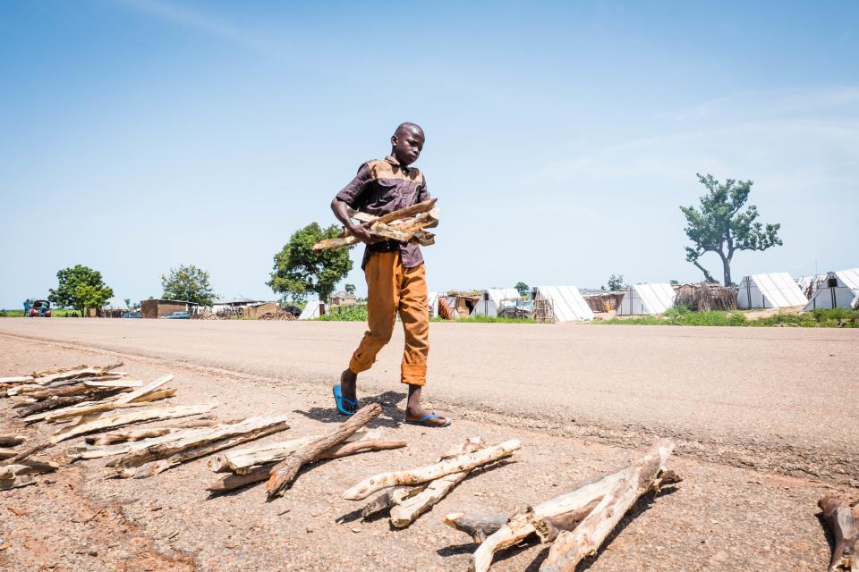 Mohammed collects firewood and piles it on the side of road in Sabon Gari, Nigeria. He is selling the wood to be able to purchase food for his family.