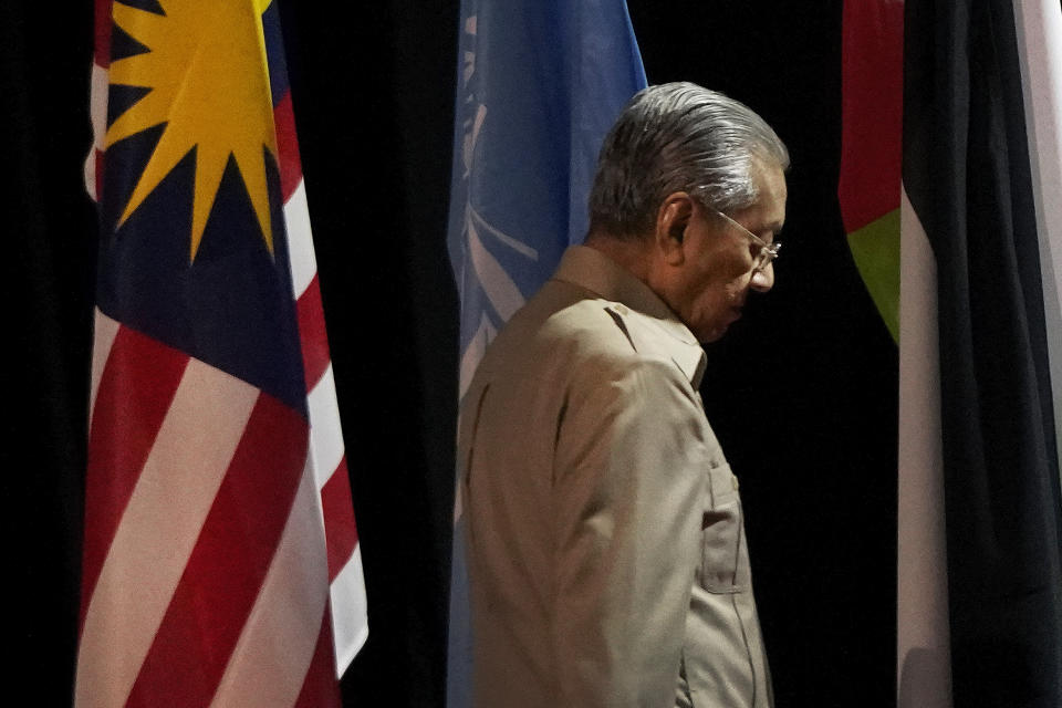 In this Friday, Feb. 28, 2020, photo, Malaysia's interim leader Mahathir Mohamad leaves after delivering a speech at the committee on the exercise of the inalienable rights of the Palestinian people, in Kuala Lumpur, Malaysia. Mahathir indicated Saturday that he will reconcile with the former ruling alliance he led with rival Anwar Ibrahim in an about-turn that follows a week of political turmoil that followed his resignation as prime minister. (AP Photo/Vincent Thian)