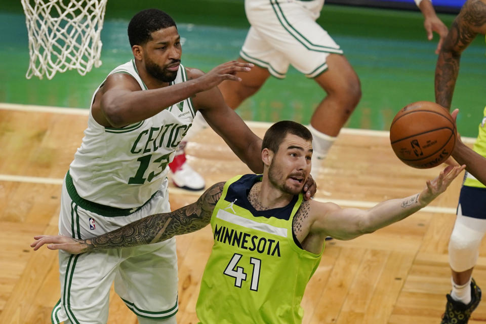 Minnesota Timberwolves forward Juancho Hernangomez (41) grabs a rebound in front of Boston Celtics center Tristan Thompson (13) in the first quarter of an NBA basketball game, Friday, April 9, 2021, in Boston. (AP Photo/Elise Amendola)