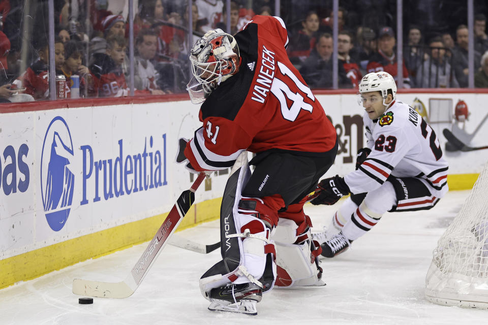 New Jersey Devils goaltender Vitek Vanecek clears the puck in front of Chicago Blackhawks center Philipp Kurashev (23) during the first period of an NHL hockey game Friday, Jan. 5, 2024, in Newark, N.J. (AP Photo/Adam Hunger)