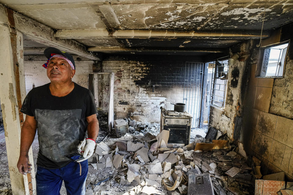 Marco Delgadillo stands at his home burnt when forest fires reached El Olivar neighborhood, in Vina del Mar, Chile, Monday, Feb. 5, 2024. Areas around Vina del Mar were among the hardest-hit by fires that broke out in central Chile three day earlier, resulting in the deaths of more than a hundred people. (AP Photo/ Esteban Felix)